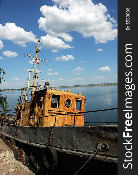 Panorama of calm river and old motor boat over cloudy sky. Panorama of calm river and old motor boat over cloudy sky