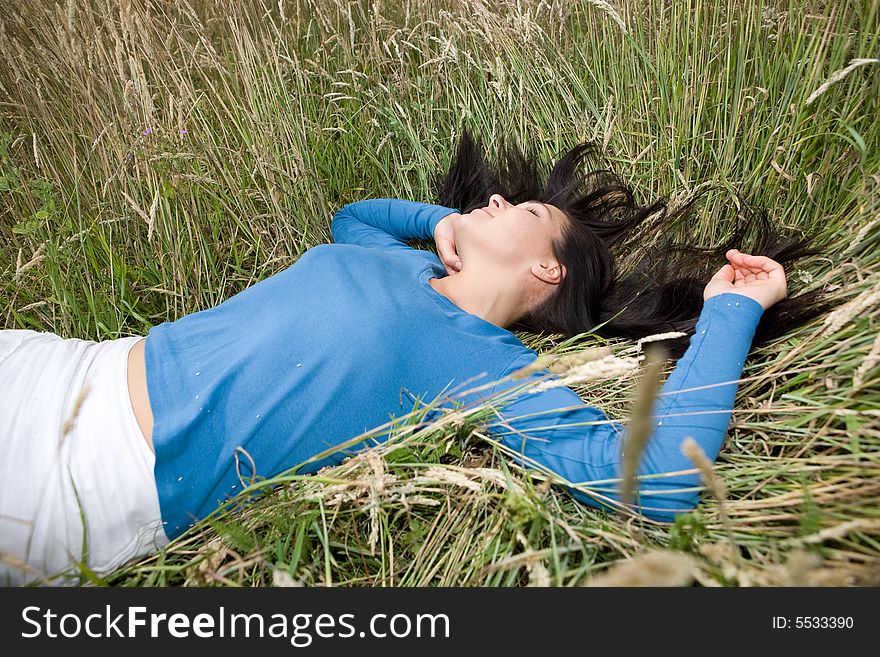 Attractive brunette woman relaxing on  meadow. Attractive brunette woman relaxing on  meadow