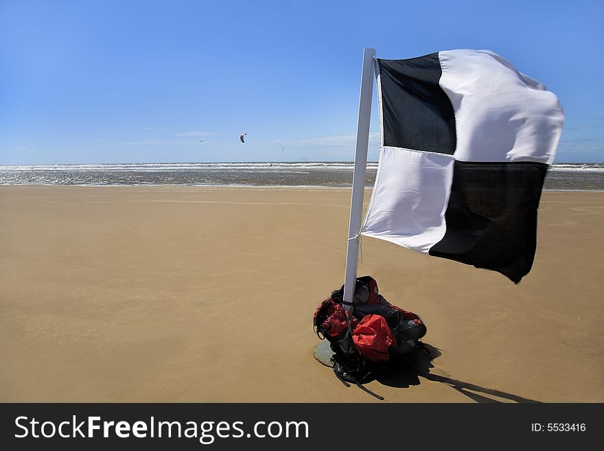 Beach Scene with Kitesurfing and flag