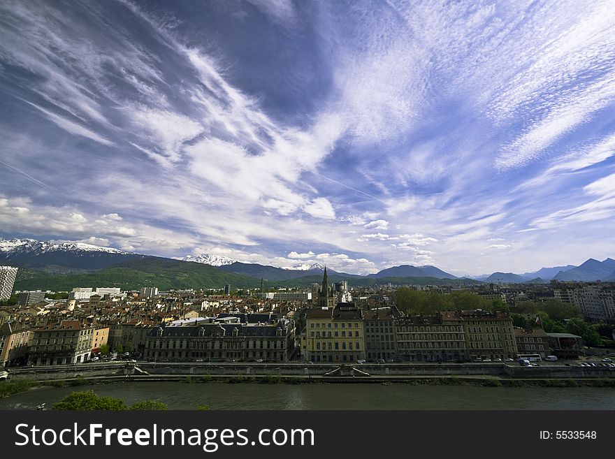 Wide angle view of Grenoble with Isere at the bottom and cloudy sky. Wide angle view of Grenoble with Isere at the bottom and cloudy sky.