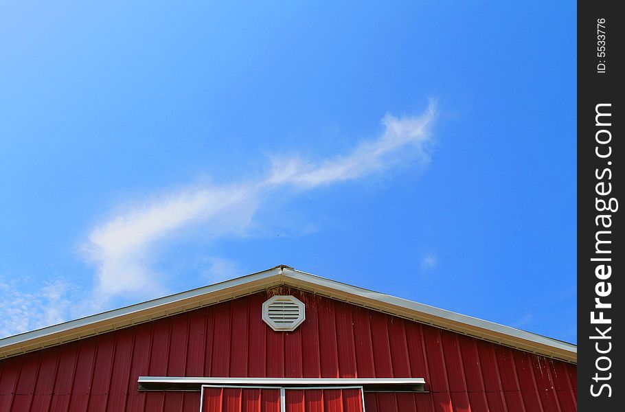 The roof a barn with a bright blue sky in the background. The roof a barn with a bright blue sky in the background