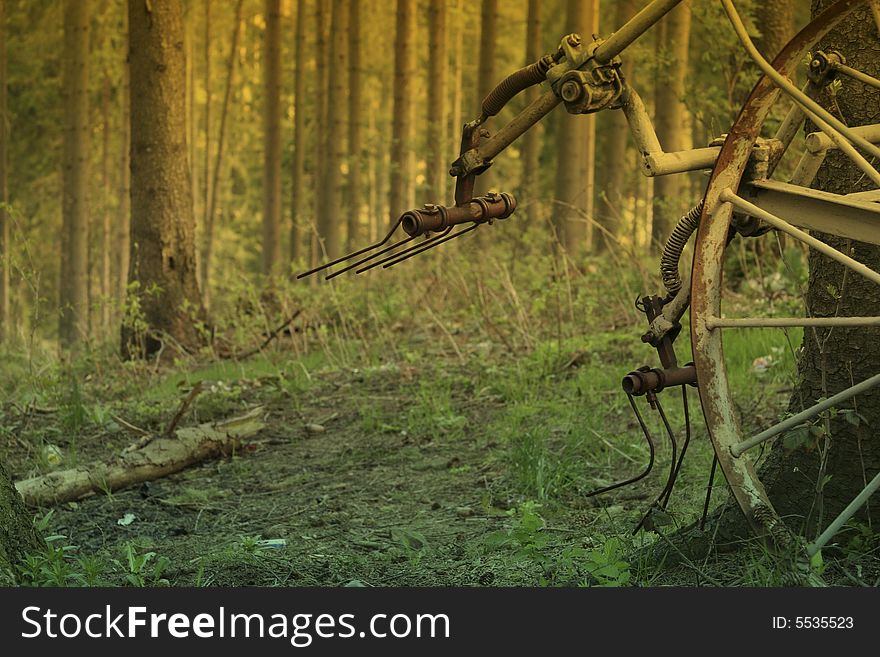 Old machine for ploughing standing in the forest