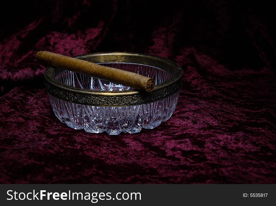 An expensive cigar on glass ashtray