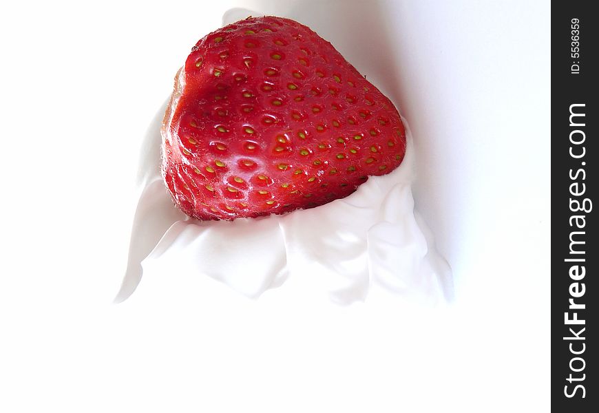 A close up of a sweet strawberry with lots of fresh cream. A close up of a sweet strawberry with lots of fresh cream