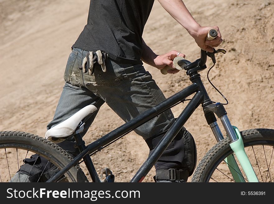 Biker with a bicycle in hands.