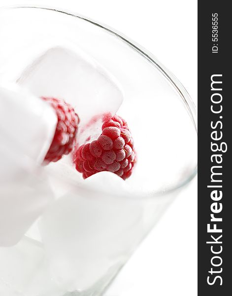 Frozen raspberries with ice in glass