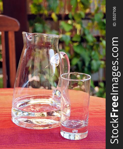 Close up of decanter and glass with water standing on table. Close up of decanter and glass with water standing on table.