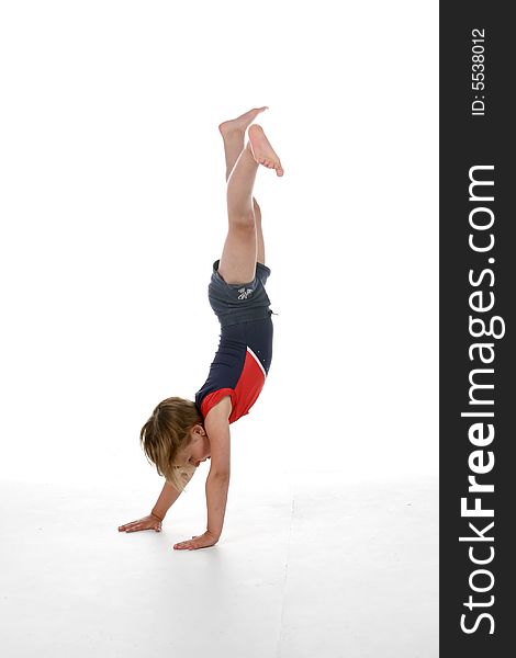 Young girl doing a handstand against a high key background