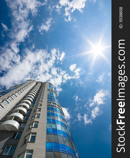 Tall office or residental building on blue sky with clouds. Wide-angle lens used. Tall office or residental building on blue sky with clouds. Wide-angle lens used.