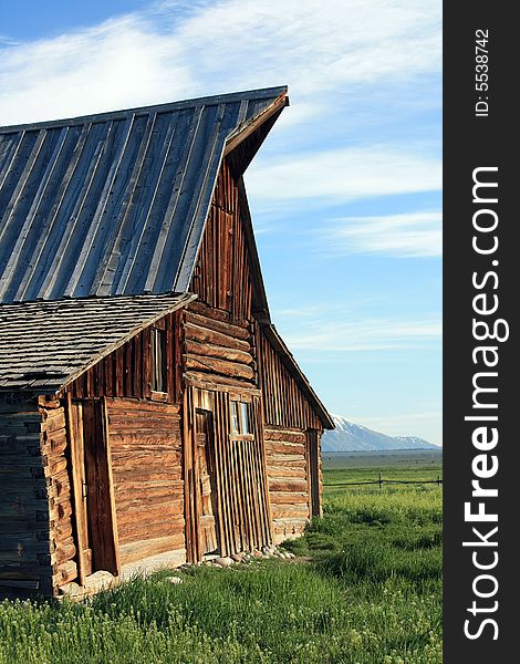 Side view of facade of old barn in field in the Rocky Mountains. Side view of facade of old barn in field in the Rocky Mountains