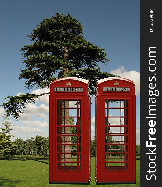 Two red phone boxes in the park. Two red phone boxes in the park