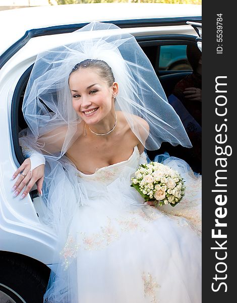 A bride leaves the car. A bride leaves the car