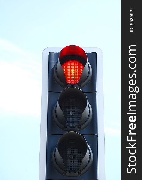 Red traffic light signal against cloudy blue sky. Red traffic light signal against cloudy blue sky