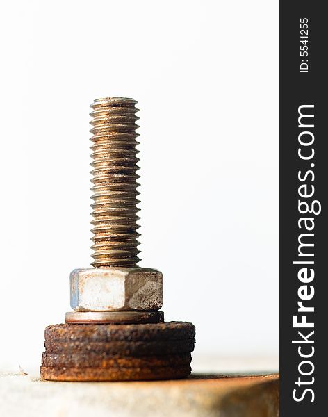 Attachment made of a threaded bolt and a nut atop a pile of rusty washers. Attachment made of a threaded bolt and a nut atop a pile of rusty washers