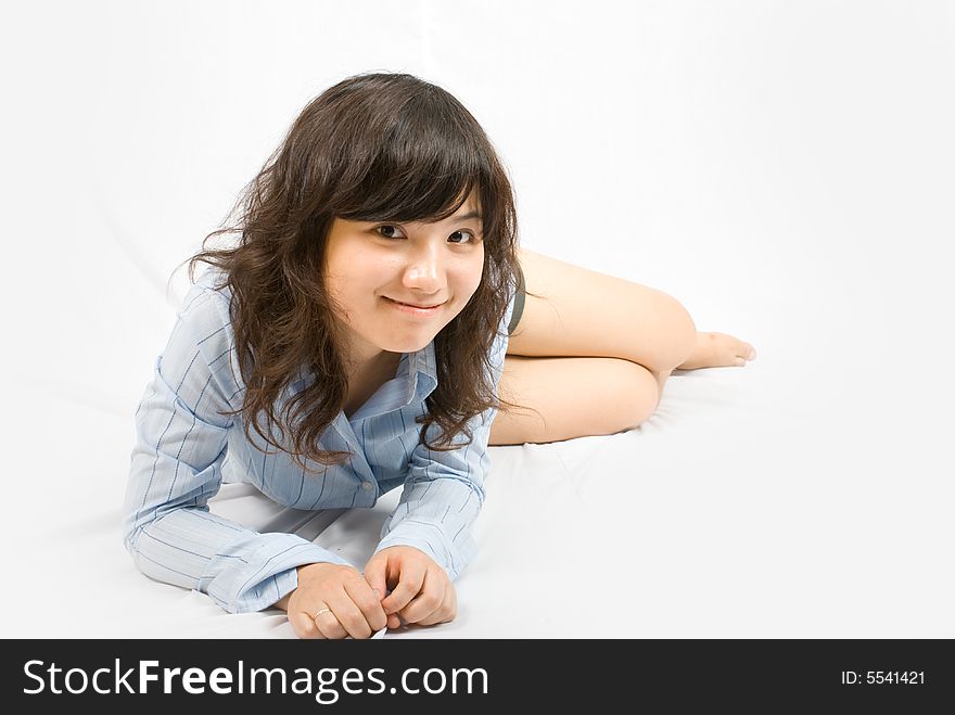 A young asian belle with knickers and light blue shirt lies on the white ground. A young asian belle with knickers and light blue shirt lies on the white ground