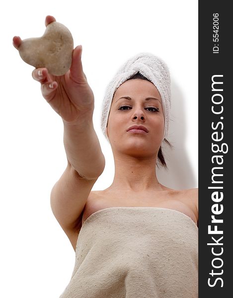Young woman lying for treatment at a spa holding heart stone. Young woman lying for treatment at a spa holding heart stone