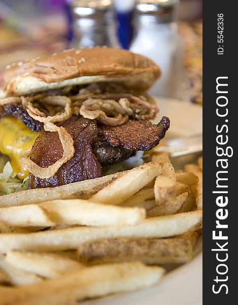 A tasty bacon cheeseburger and hot french fries. A tasty bacon cheeseburger and hot french fries