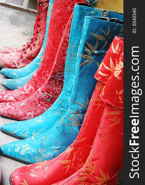 Handmade silk boots on display at a shop in Hoi An, Vietnam - travel and tourism. Handmade silk boots on display at a shop in Hoi An, Vietnam - travel and tourism.