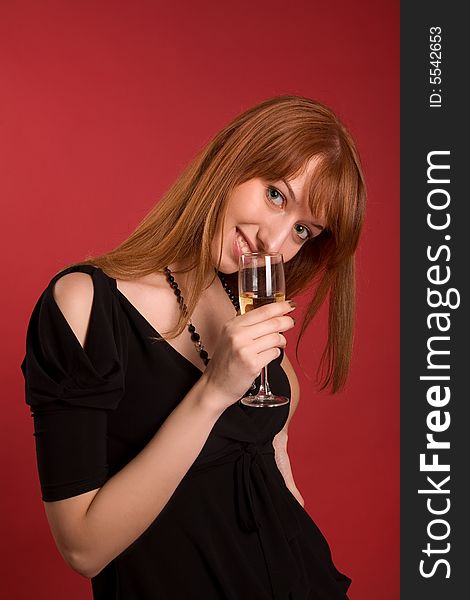 Smiling girl with champagne glass isolated on red background