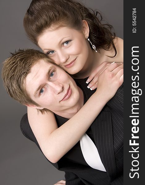Portrait of a young beautiful couple embracing. (gray background)