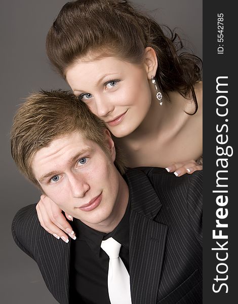 Portrait of a young beautiful couple embracing. (gray background)