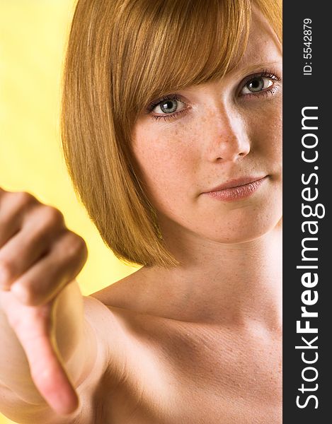 Portrait of a young unhappy woman with thumb down. Portrait of a young unhappy woman with thumb down