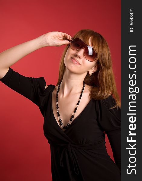 Attractive girl in eyeglasses isolated on red background