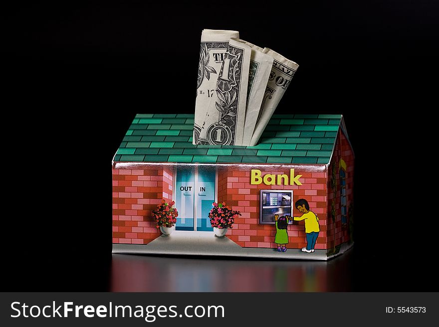 Dollar bills and cardboard bank box on black background