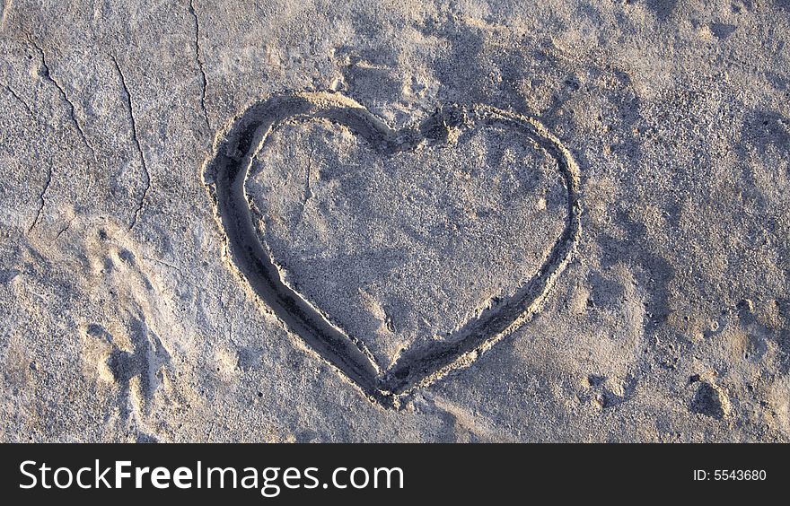 A heart shape in concrete in warm sunlight. A heart shape in concrete in warm sunlight