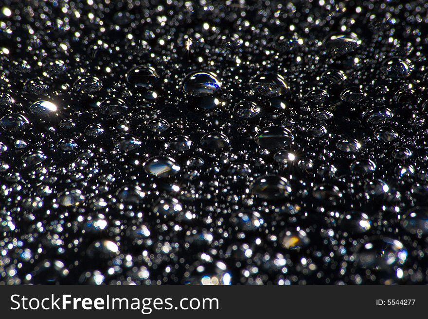 Droplets of water on a black glass surface. Droplets of water on a black glass surface