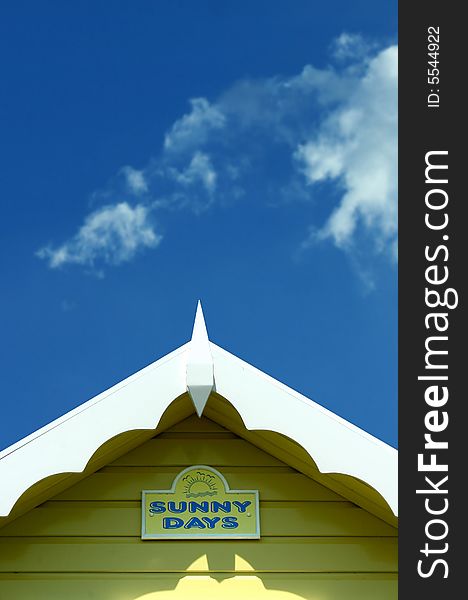 Roof line of a bright yellow beach hut with blue sky. Roof line of a bright yellow beach hut with blue sky