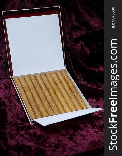 Luxury cigarillo package on crimson velvet