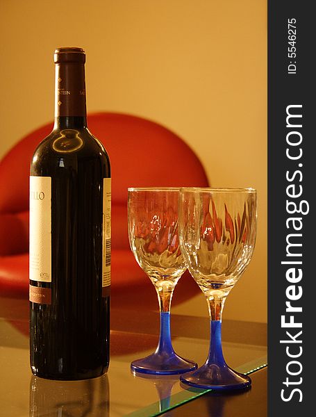 Two empty glass and a red wine bottle. Two empty glass and a red wine bottle.