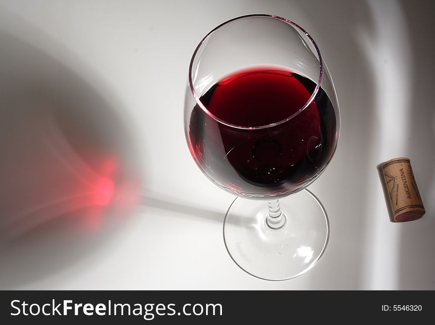 A glass of red wine and a red wine reflection. A glass of red wine and a red wine reflection