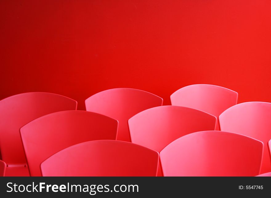 A groups of red chairs against a background of the same colour. A groups of red chairs against a background of the same colour