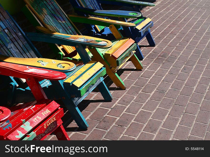 A group of very colorfully painted wooden chairs. A group of very colorfully painted wooden chairs.
