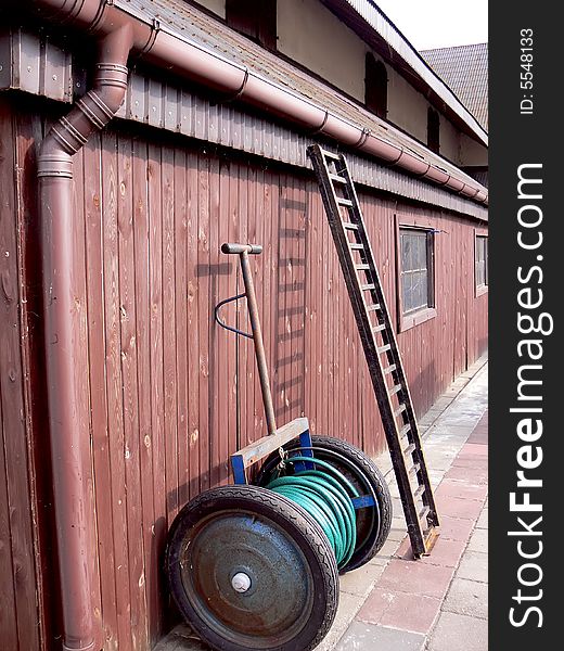 Close-up of the equipment on the farm. Wooden wall and  leaning ladder.