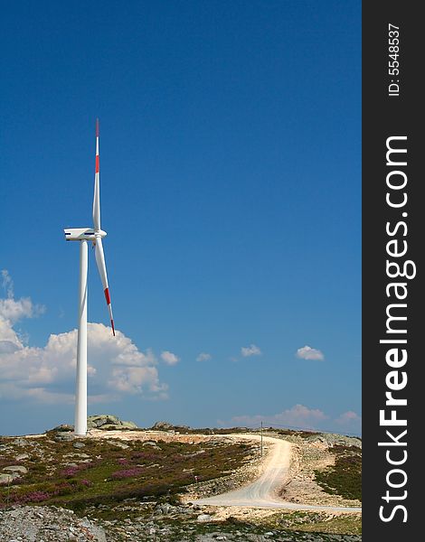 Wind turbine against blue sky.