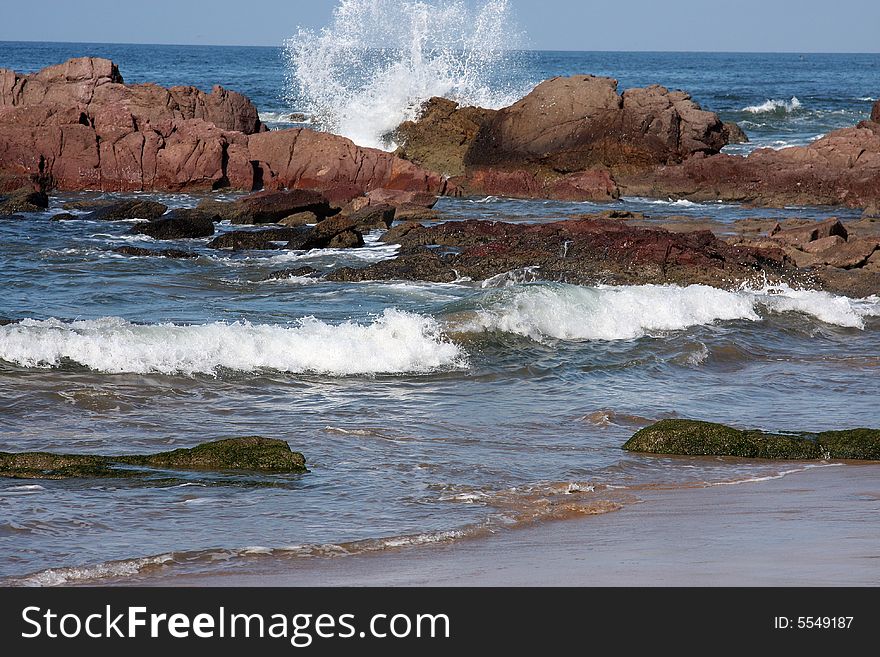 Waves breaking and crashing on the rocks on beach