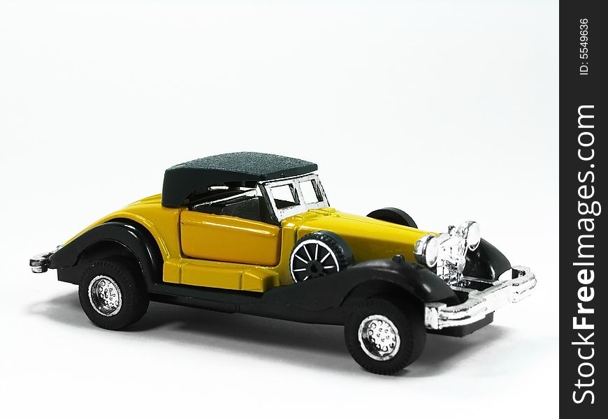 A isolated yellow and classic toy car. A isolated yellow and classic toy car.