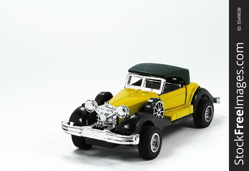 A isolated yellow and classic toy car. A isolated yellow and classic toy car.