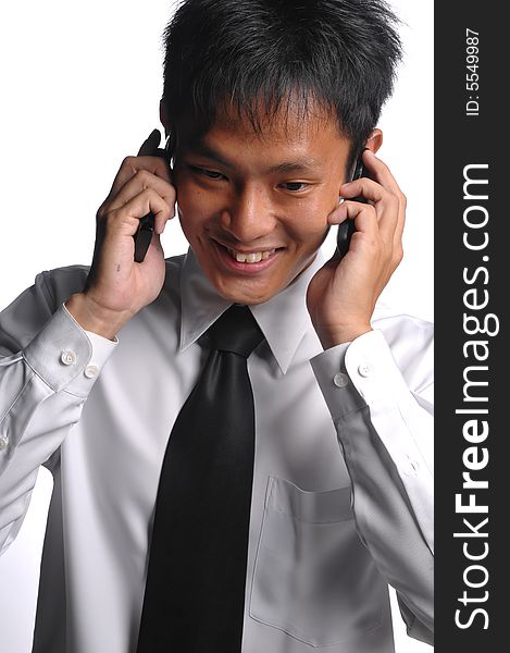 Asian business man conversing with multiple handphones. Asian business man conversing with multiple handphones