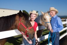 Couple In Cowboy Hats With Horses - Horizontal Royalty Free Stock Photography Couple In Cowboy Hats With Horses - Horizontal Royalty Free Stock Photography