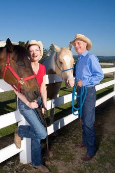 Couple In Cowboy Hats With Horses - Vetical Royalty Free Stock Images Couple In Cowboy Hats With Horses - Vetical Royalty Free Stock Images