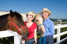Couple In Cowboy Hats With Horses - Horizontal Royalty Free Stock Image