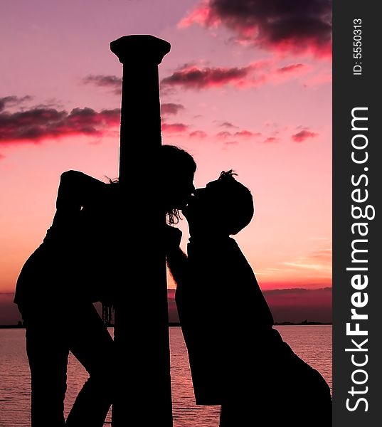 Romantic couple kissing at sunset. Romantic couple kissing at sunset