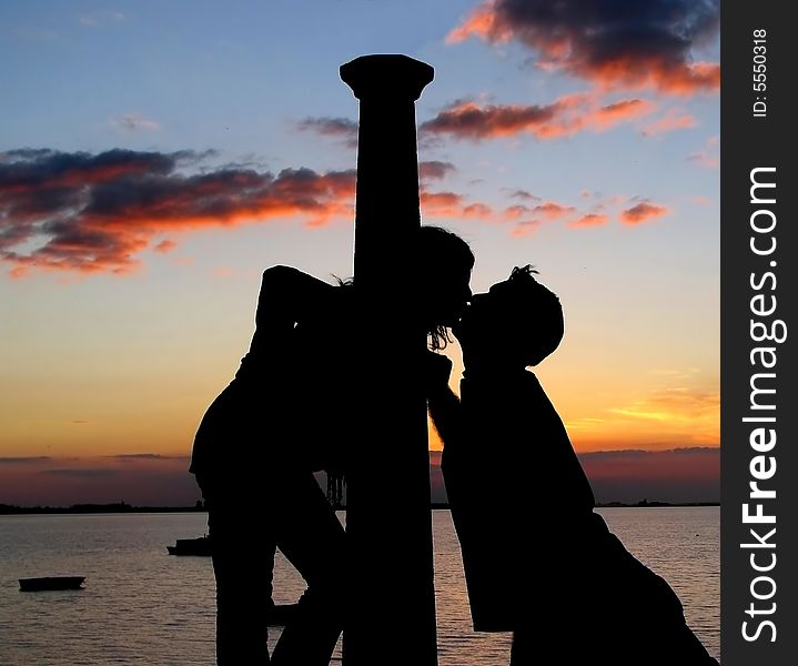 A couple silhouette kissing at beautiful sunset. A couple silhouette kissing at beautiful sunset