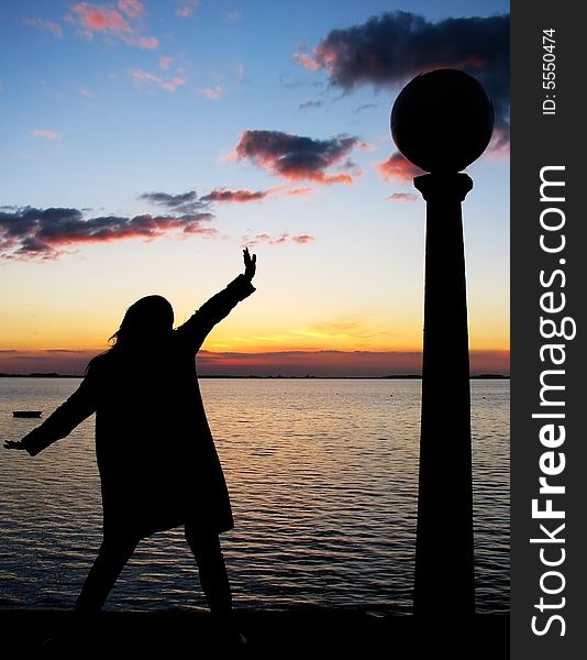 Woman silhouette against sunset background in the lake. Woman silhouette against sunset background in the lake.