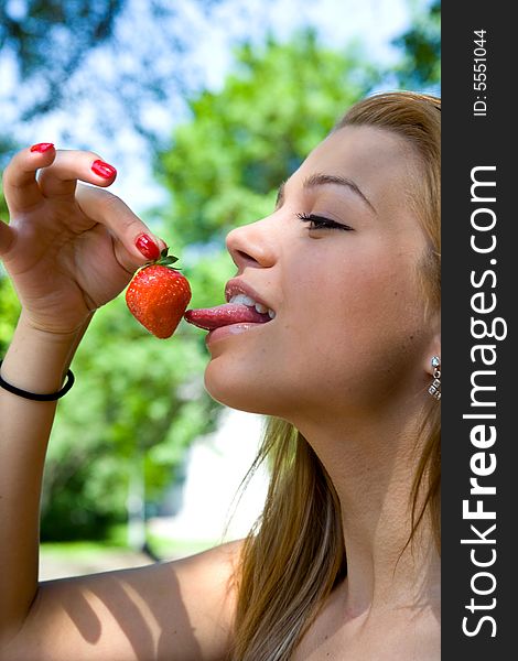 Portrait of the beautiful young girl on nature with strawberries. Portrait of the beautiful young girl on nature with strawberries