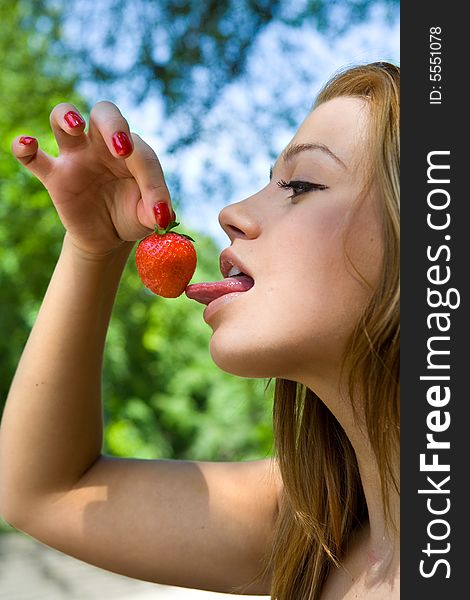 Portrait of the beautiful young girl on nature with strawberries. Portrait of the beautiful young girl on nature with strawberries